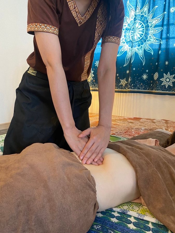 チネイザンの施術。お腹に両手を重ねてゆっくりと圧を届けている