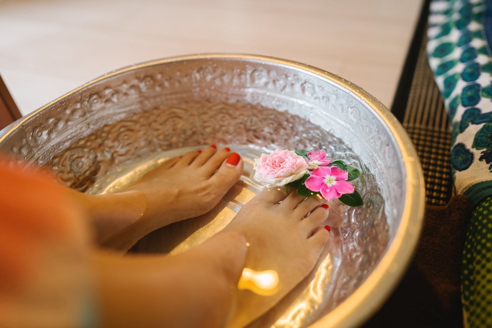 花を浮かべた銀の器で足元をあたためている様子